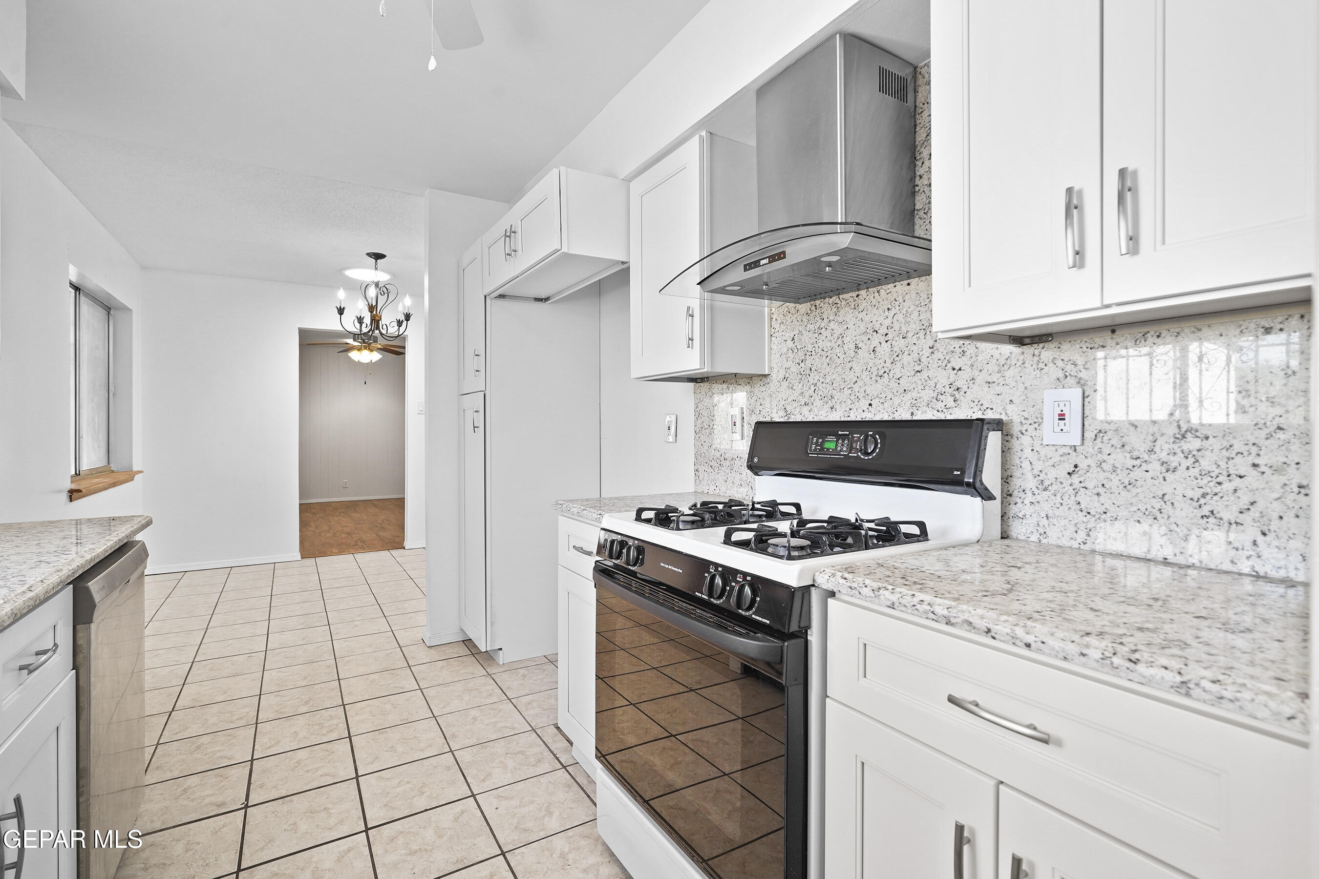 416 San Saba Road El Paso, TX 79912 - Photo 13 of 41 a kitchen with granite countertop a stove a sink and a refrigerator