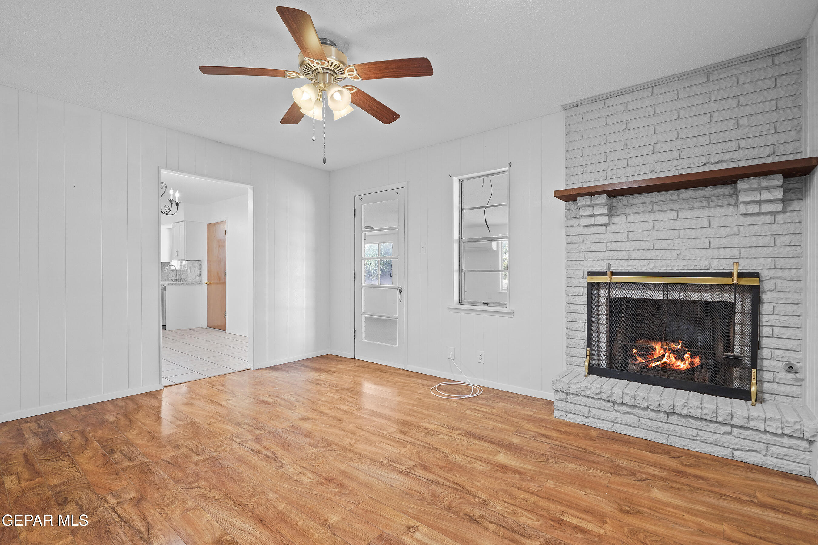416 San Saba Road El Paso, TX 79912 - Photo 18 of 41 a view of an empty room with wooden floor fireplace and a window