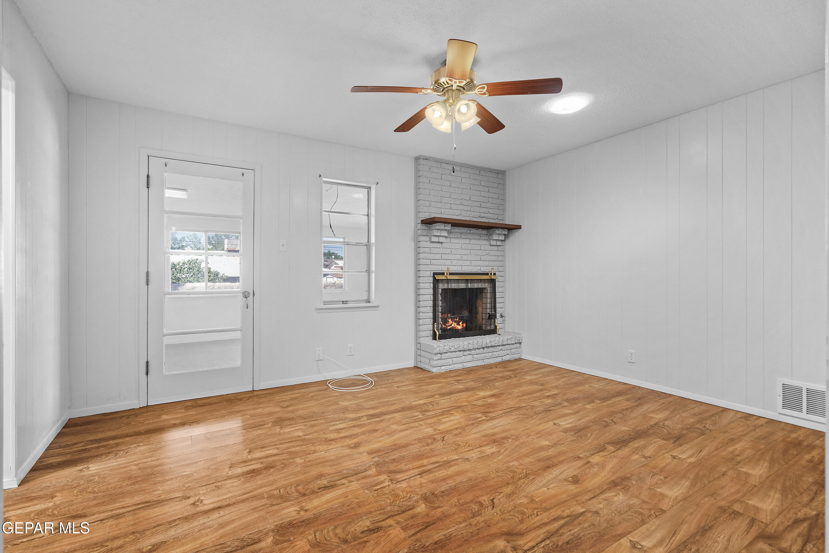 416 San Saba Road El Paso, TX 79912 - Photo 19 of 41 a view of empty room with wooden floor and fireplace
