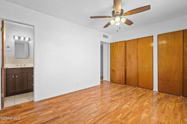 a view of a big room with wooden floor and a chandelier fan