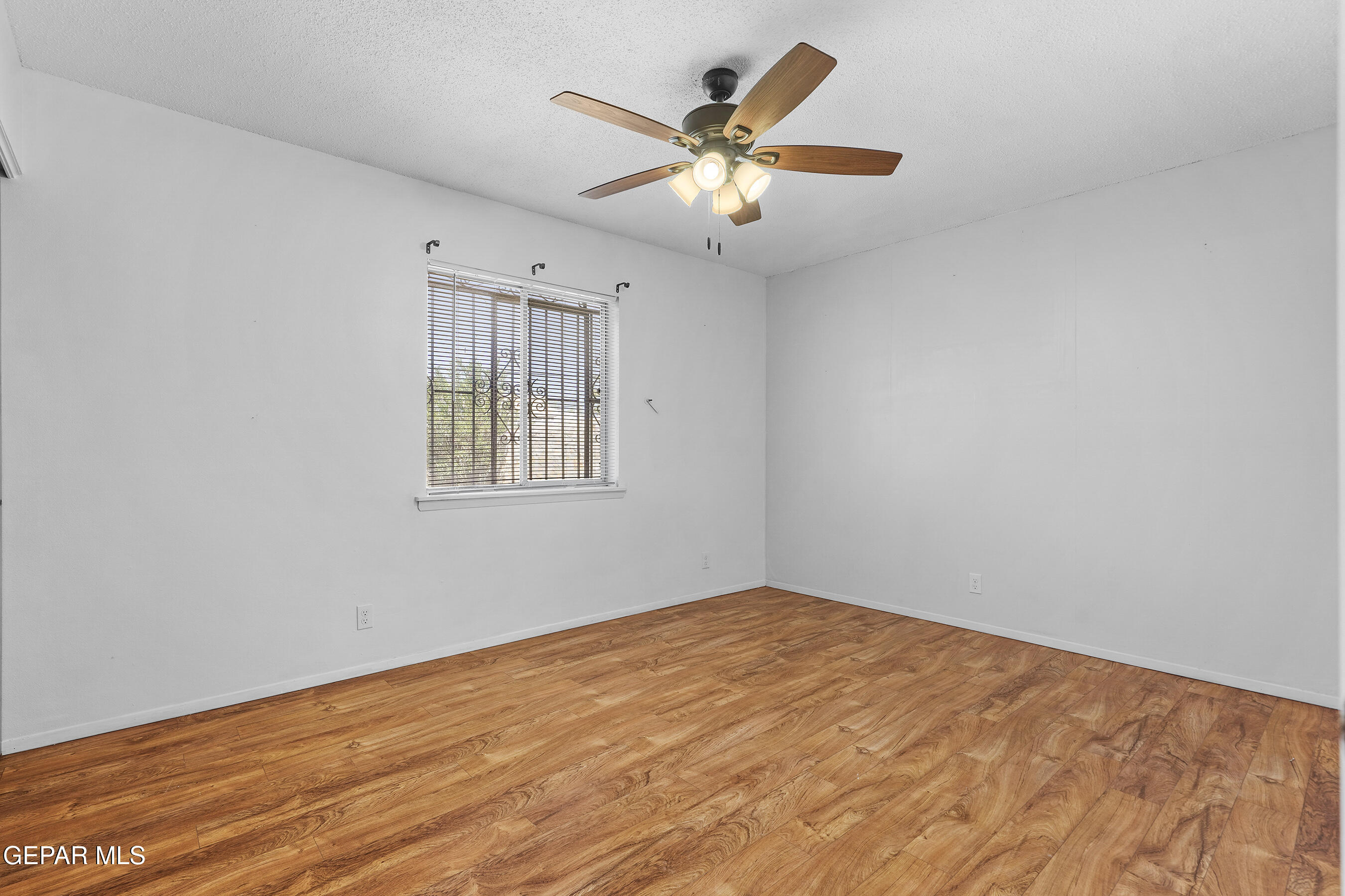 416 San Saba Road El Paso, TX 79912 - Photo 26 of 41 an empty room with wooden floor and windows