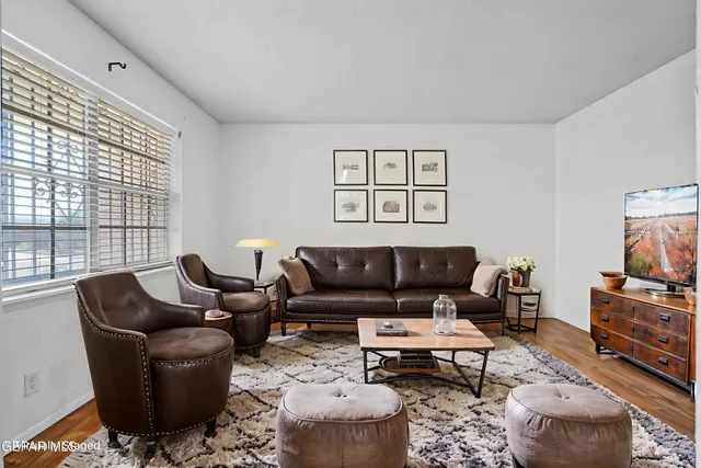 a living room with furniture a rug and a flat screen tv