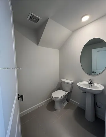 a bathroom with a sink toilet and a mirror