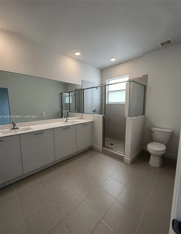a bathroom with a double vanity sink mirror and toilet