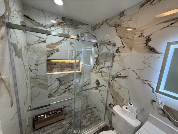 a bathroom with a sink vanity and shower