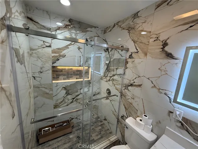 a bathroom with a sink vanity and shower
