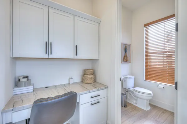 a bathroom with a granite countertop toilet a sink and a mirror