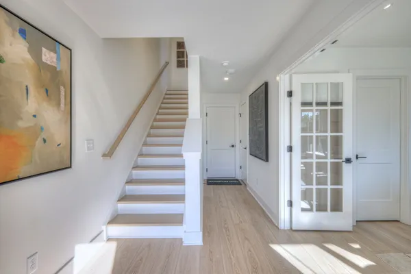 a view of a hallway with wooden floor and entryway