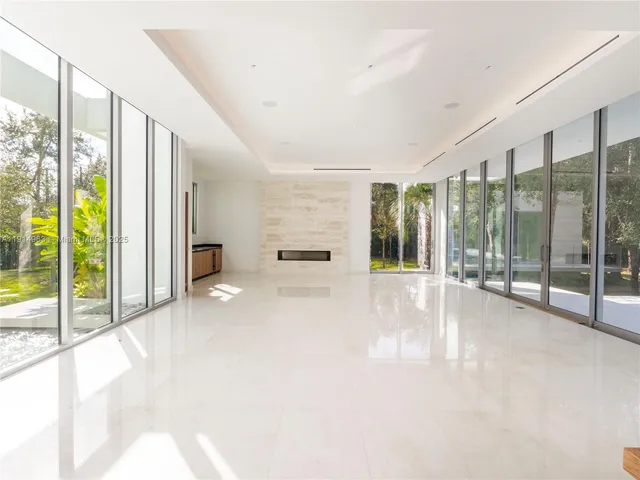 a large white kitchen with kitchen island a large window in it