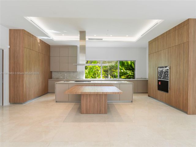 a living room with stainless steel appliances granite countertop a sink and a refrigerator