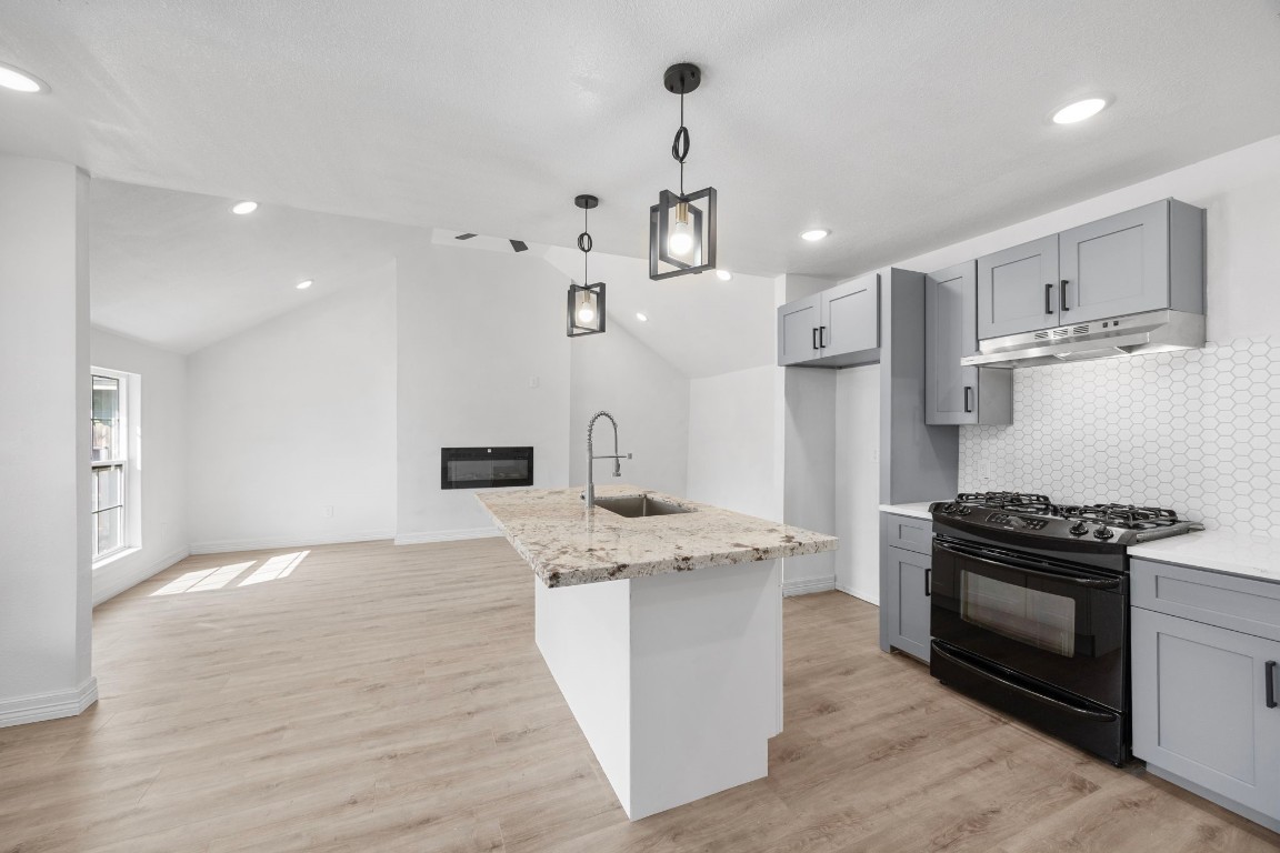 905 Elm Avenue Pasadena, TX 77506 - Photo 8 of 21 a kitchen with stainless steel appliances granite countertop a stove a sink a refrigerator and a wooden floor