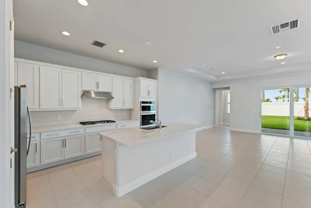 a kitchen with stainless steel appliances a stove a sink a microwave and cabinets