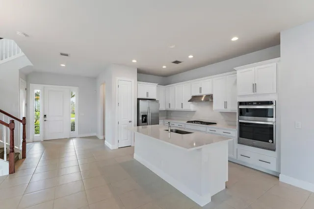 a kitchen with a refrigerator a sink and a stove top oven