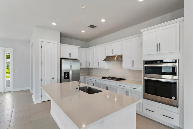 a kitchen with refrigerator stove and cabinets
