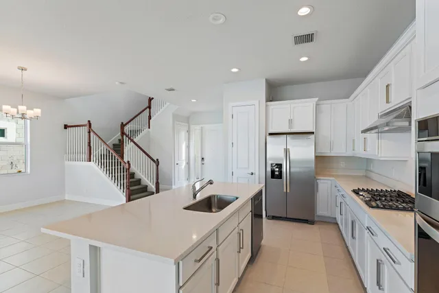 a kitchen with stainless steel appliances kitchen island granite countertop a sink and a stove top oven