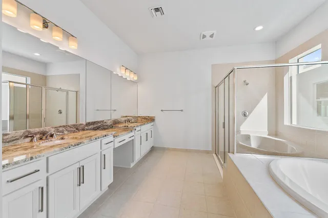 a bathroom with a granite countertop sink a mirror and a bathtub