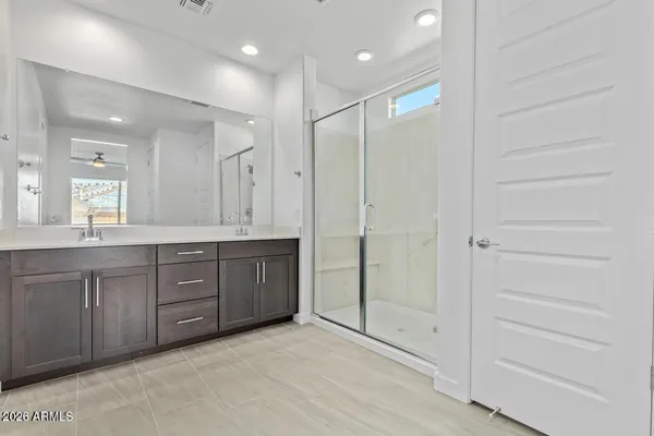 a bathroom with a granite countertop sink a mirror and a shower