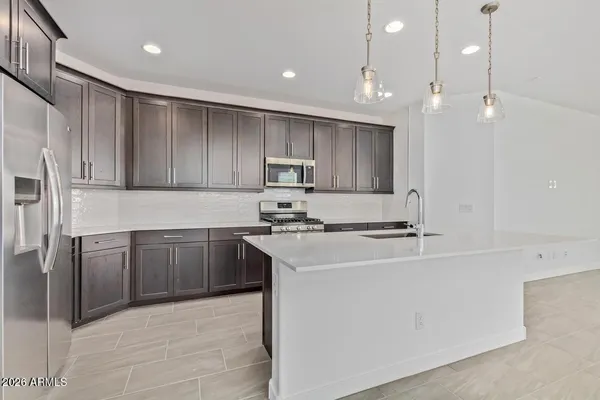 a kitchen with kitchen island a sink stainless steel appliances and cabinets
