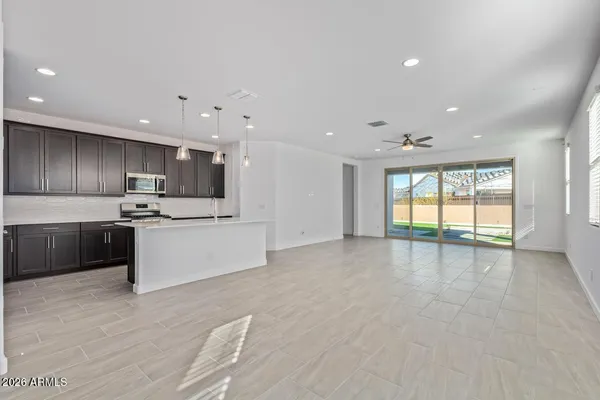 a large kitchen with stainless steel appliances a large counter top a stove and a refrigerator