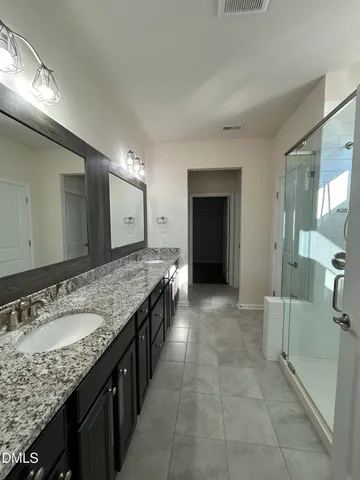 a spacious bathroom with a granite countertop sink and a mirror