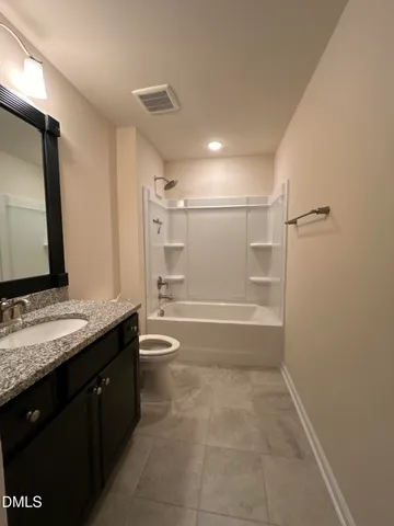 a bathroom with a granite countertop sink a toilet and a mirror