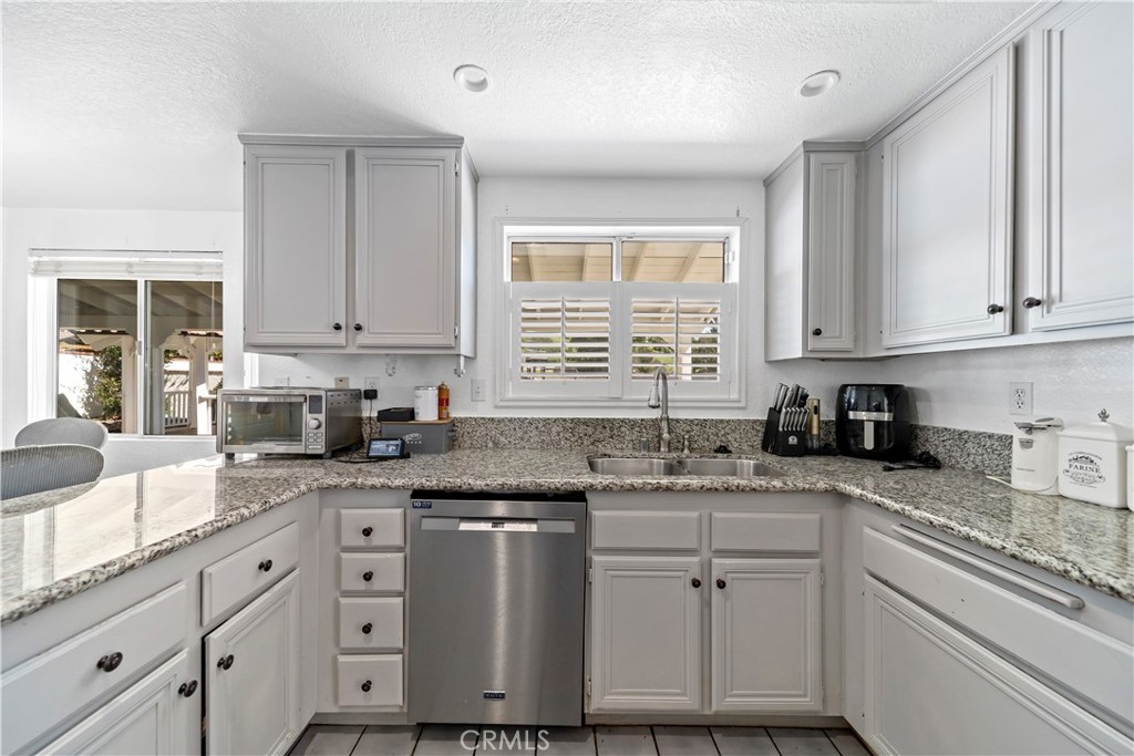 1491 Hunters Trail Glendora, CA 91740 - Photo 13 of 54 a kitchen with granite countertop white cabinets and white appliances
