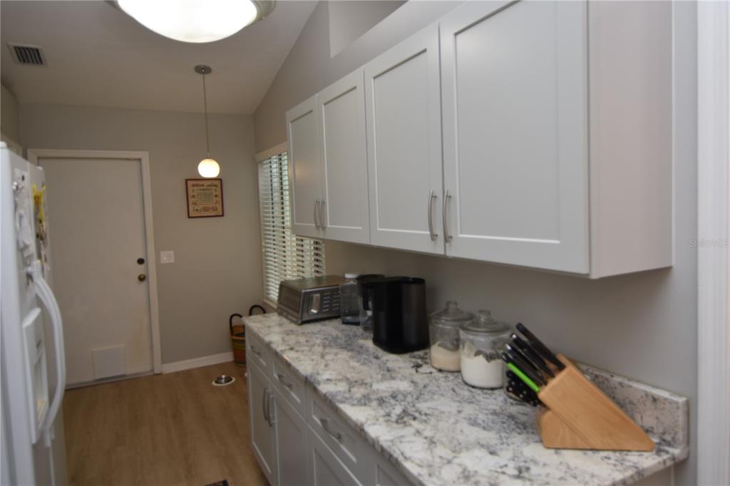 4941 Southwest 10th Lane Gainesville, FL 32607 - Photo 13 of 36 a kitchen with granite countertop a sink a stove and cabinets
