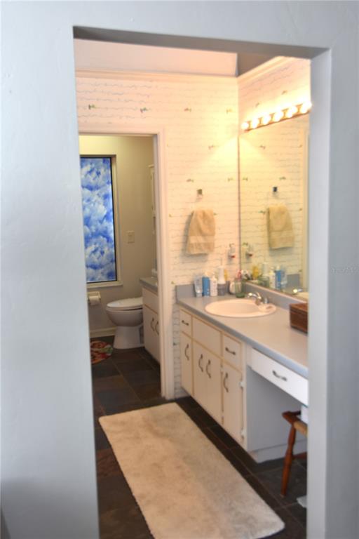 4941 Southwest 10th Lane Gainesville, FL 32607 - Photo 23 of 36 a spacious bathroom with a granite countertop sink and a large mirror