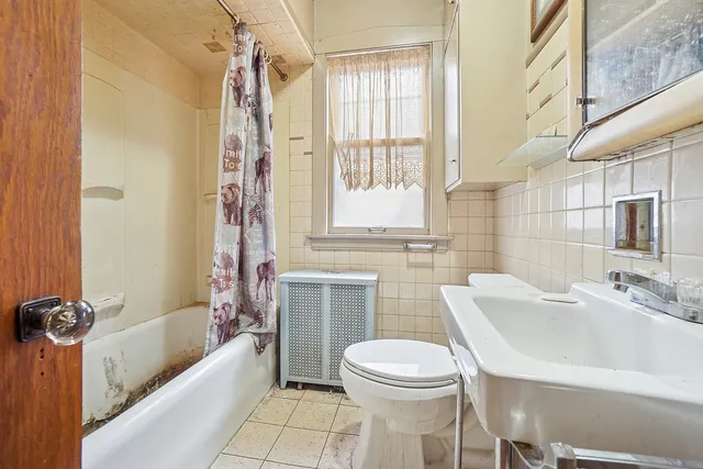 a bathroom with a sink a toilet a mirror a bathtub and shower