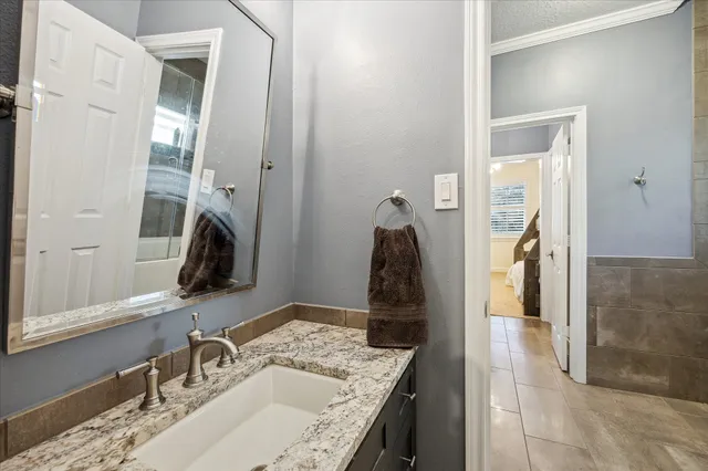 a bathroom with a granite countertop sink and a mirror