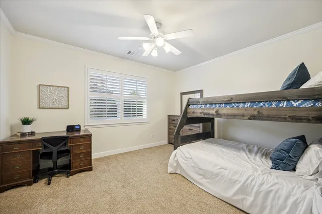 a bedroom with a bed a computer on a desk and chair