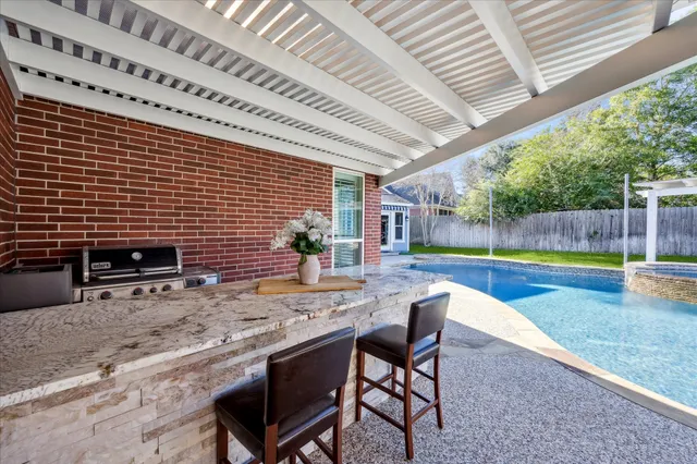 a kitchen with stainless steel appliances a dining table chairs sink and cabinets
