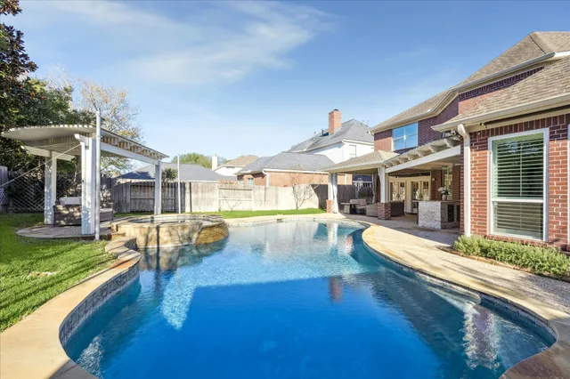 an aerial view of residential house with outdoor space and swimming pool