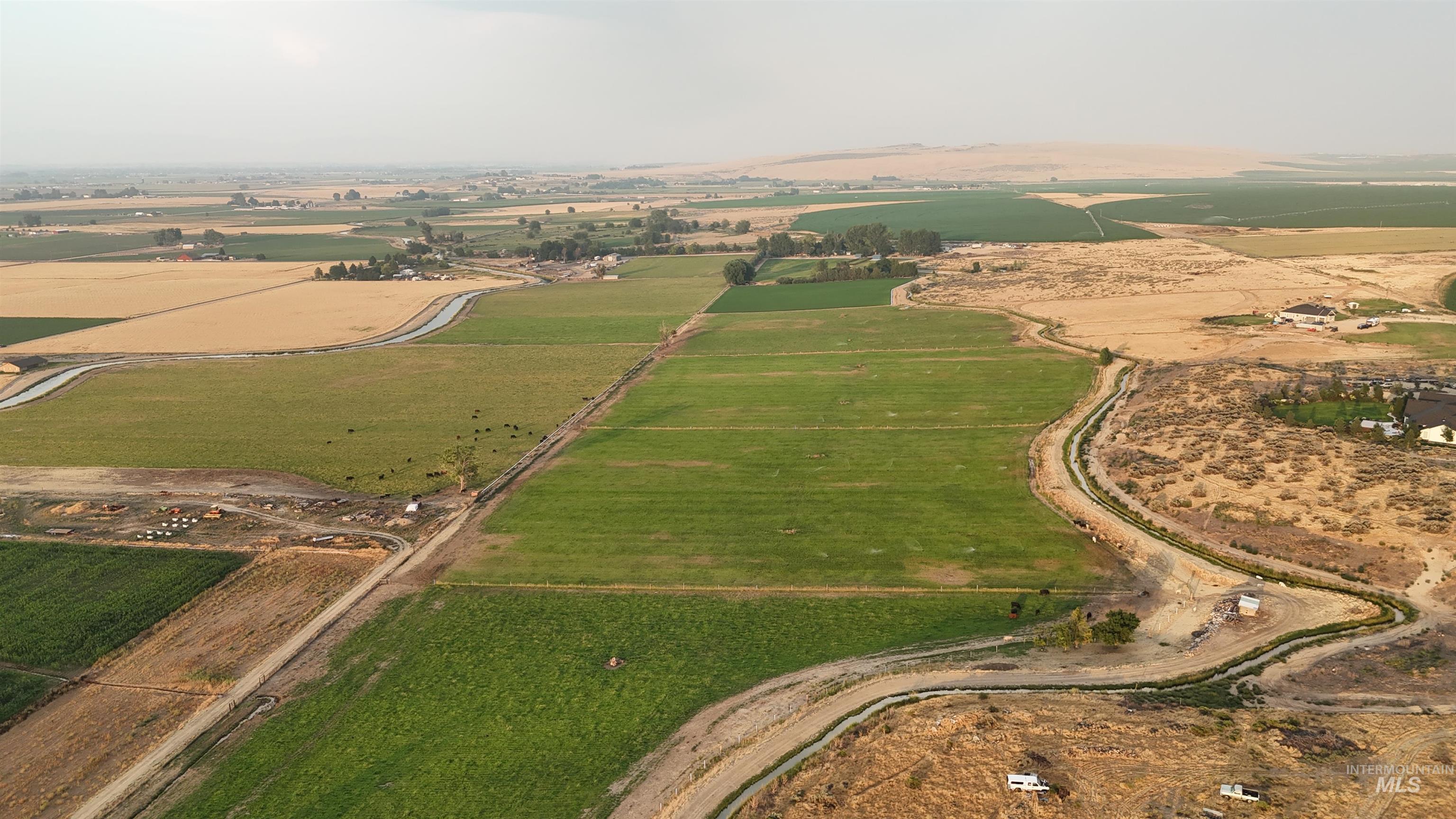 6712 Stage Coach Road Nampa, ID 83686 - Photo 28 of 48 Expansive agricultural property featuring cultivated fields, a long greenhouse structure, and various outbuildings