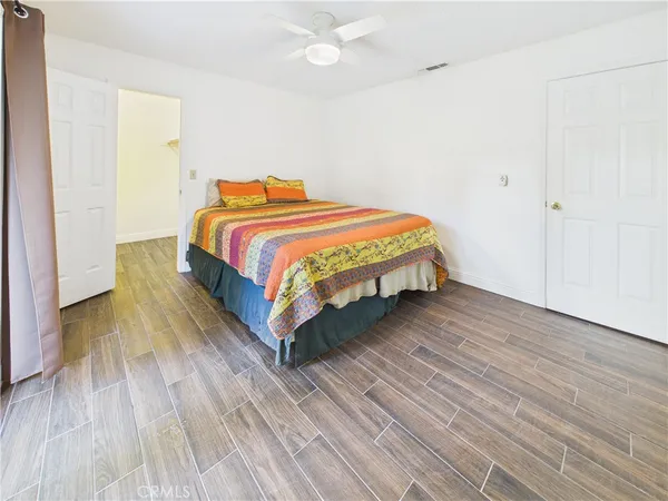 a spacious bedroom with a bed and wooden floor