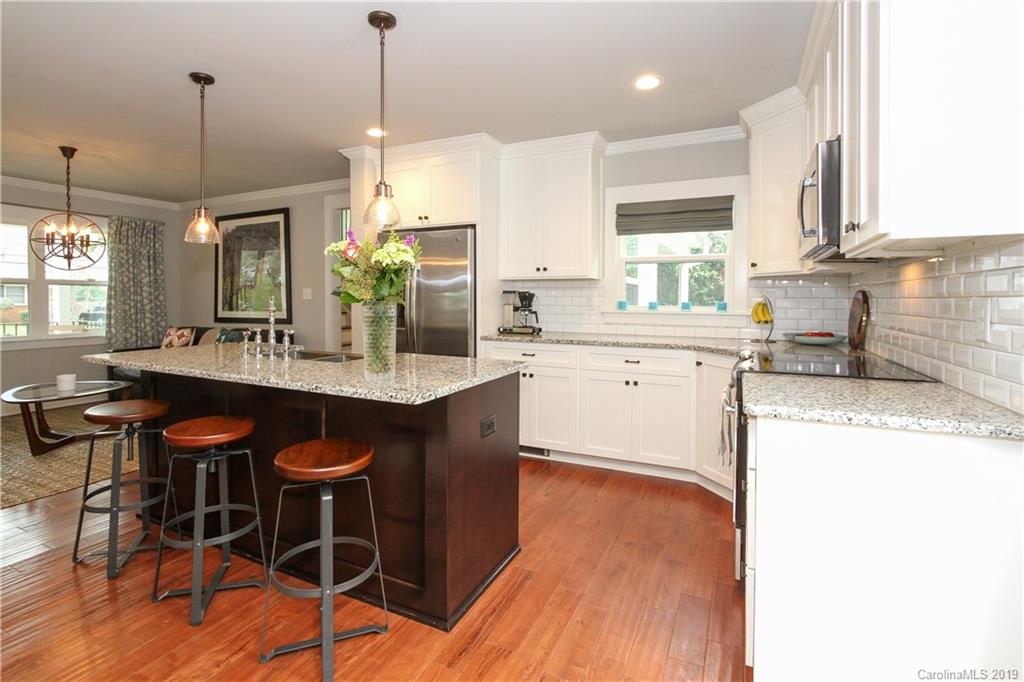 4217 Walker Road Charlotte, NC 28211 - Photo 12 of 34 a kitchen with stainless steel appliances kitchen island granite countertop a table chairs sink and cabinets