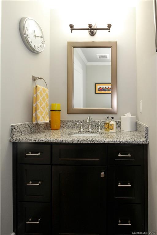 4217 Walker Road Charlotte, NC 28211 - Photo 20 of 34 a bathroom with a granite countertop sink a mirror and a wall clock