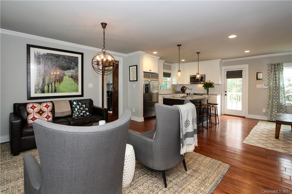 4217 Walker Road Charlotte, NC 28211 - Photo 4 of 34 a living room with furniture a chandelier and a flat screen tv