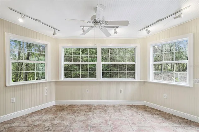a view of walk in closet with window and a ceiling fan
