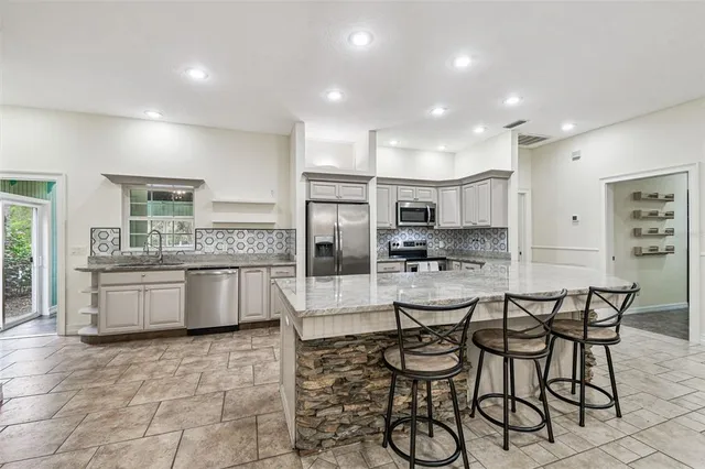 a kitchen with granite countertop a sink stainless steel appliances and cabinets