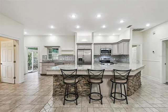 a kitchen with stainless steel appliances granite countertop a refrigerator and a sink