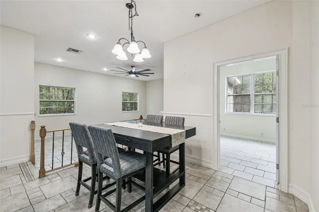 a kitchen with a dining table chairs wooden floor and kitchen view