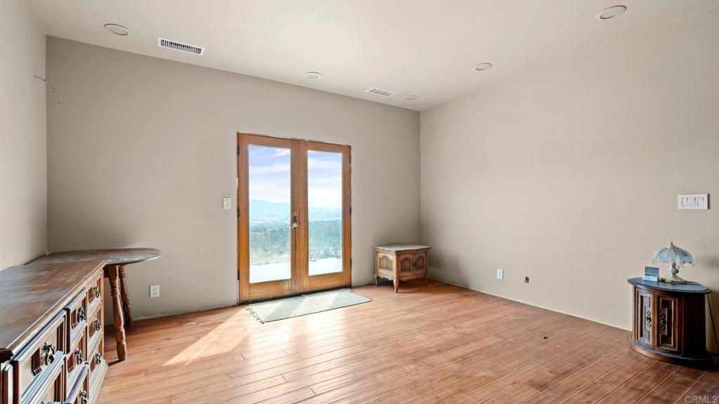 45620 Lewis Valley Road Hemet, CA 92544 - Photo 30 of 53 a view of an empty room with a window and wooden floor
