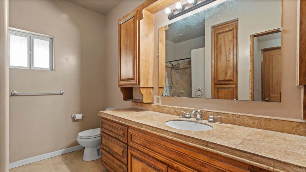45620 Lewis Valley Road Hemet, CA 92544 - Photo 31 of 53 a bathroom with a granite countertop sink toilet and mirror