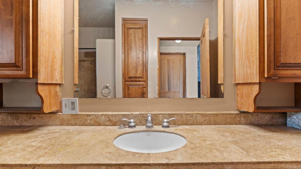 45620 Lewis Valley Road Hemet, CA 92544 - Photo 32 of 53 a bathroom with a granite countertop sink and a mirror