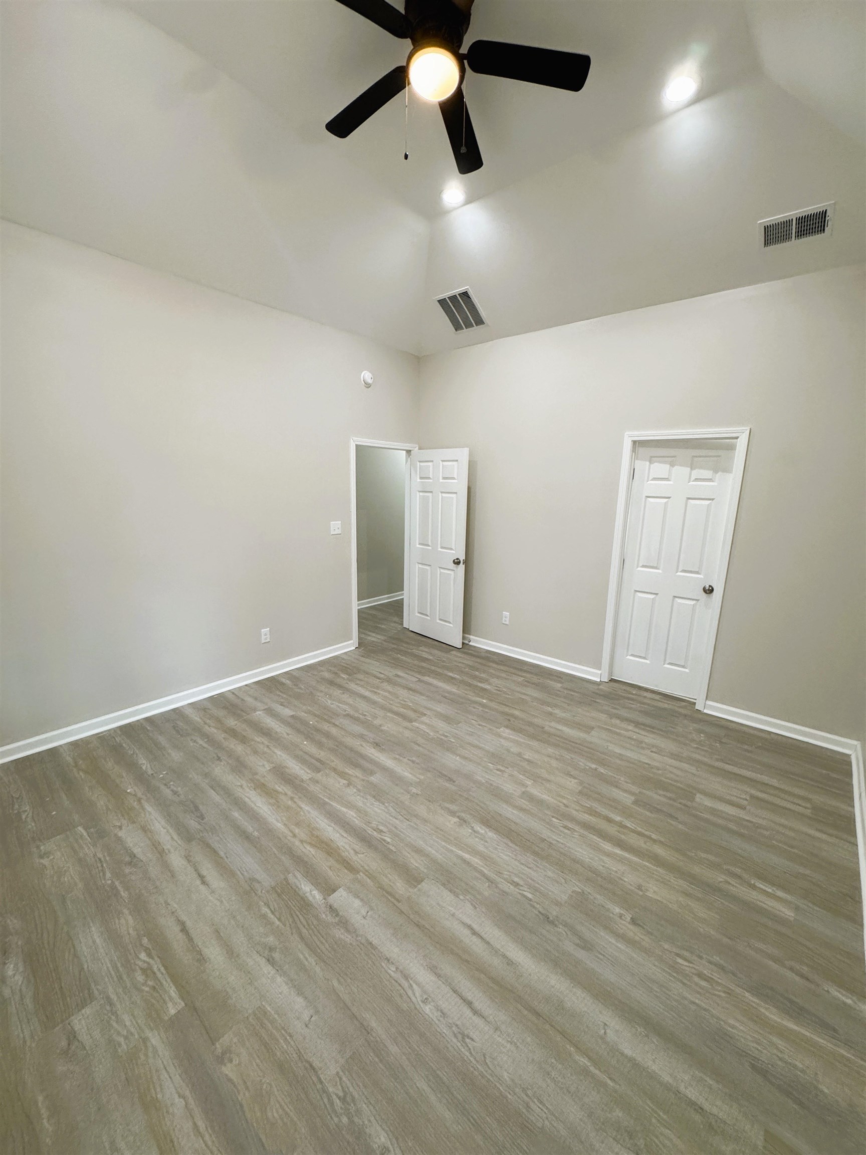 547 Berclair Road, Unit 101 Memphis, TN 38122 - Photo 13 of 19 Unfurnished bedroom featuring lofted ceiling, wood finished floors, and a ceiling fan
