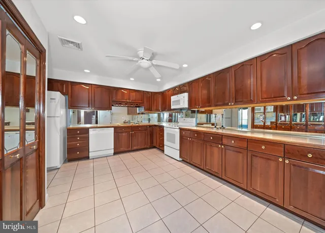 a kitchen with stainless steel appliances granite countertop a refrigerator a sink dishwasher and wooden cabinets with island