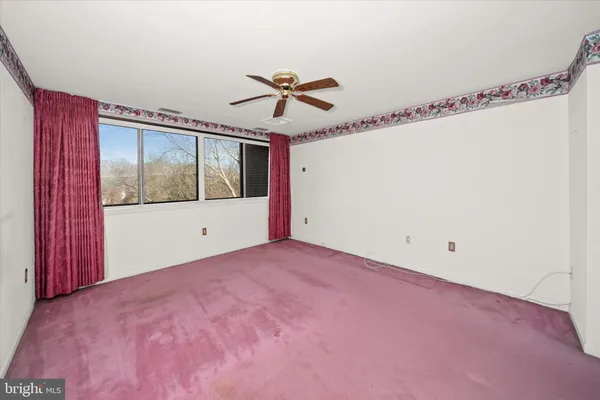 a view of a big room with wooden floor and windows