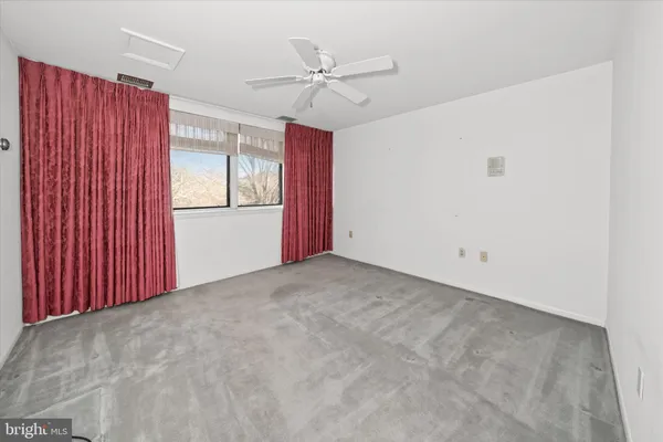 a view of a livingroom with a ceiling fan and window