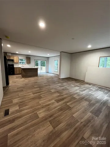 an empty room with wooden floor and fireplace
